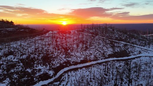 Sunrise over Ski Apache, New Mexico, captured by a drone with mountain peaks in view.