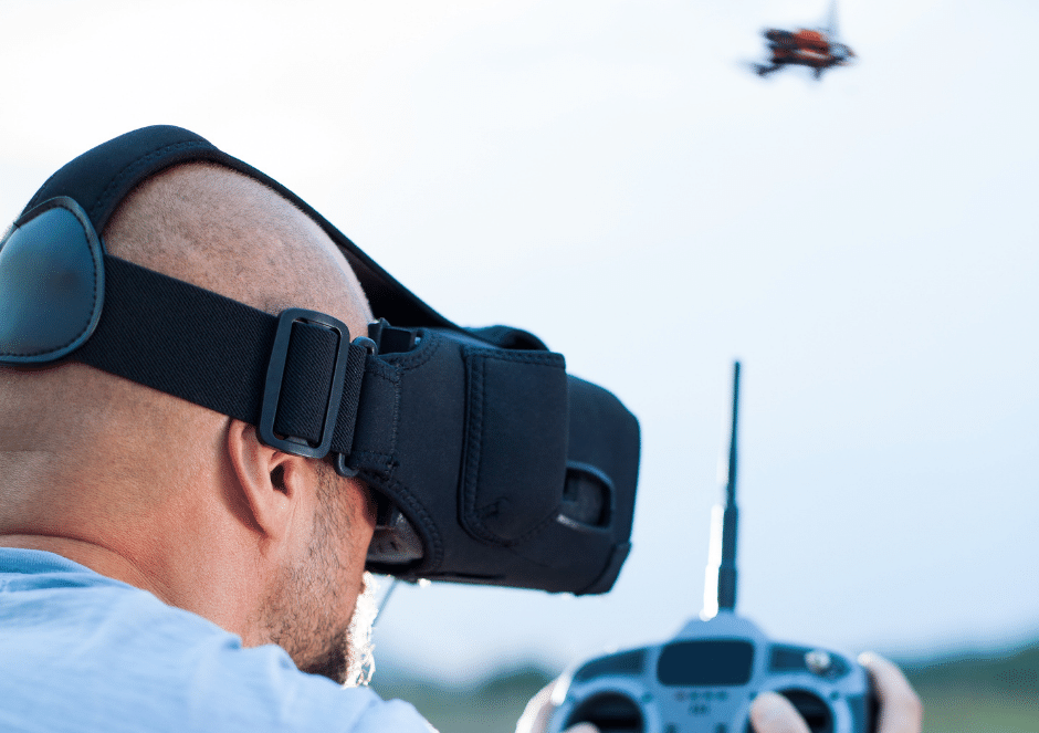 A man wearing a virtual reality headset is flying a drone.