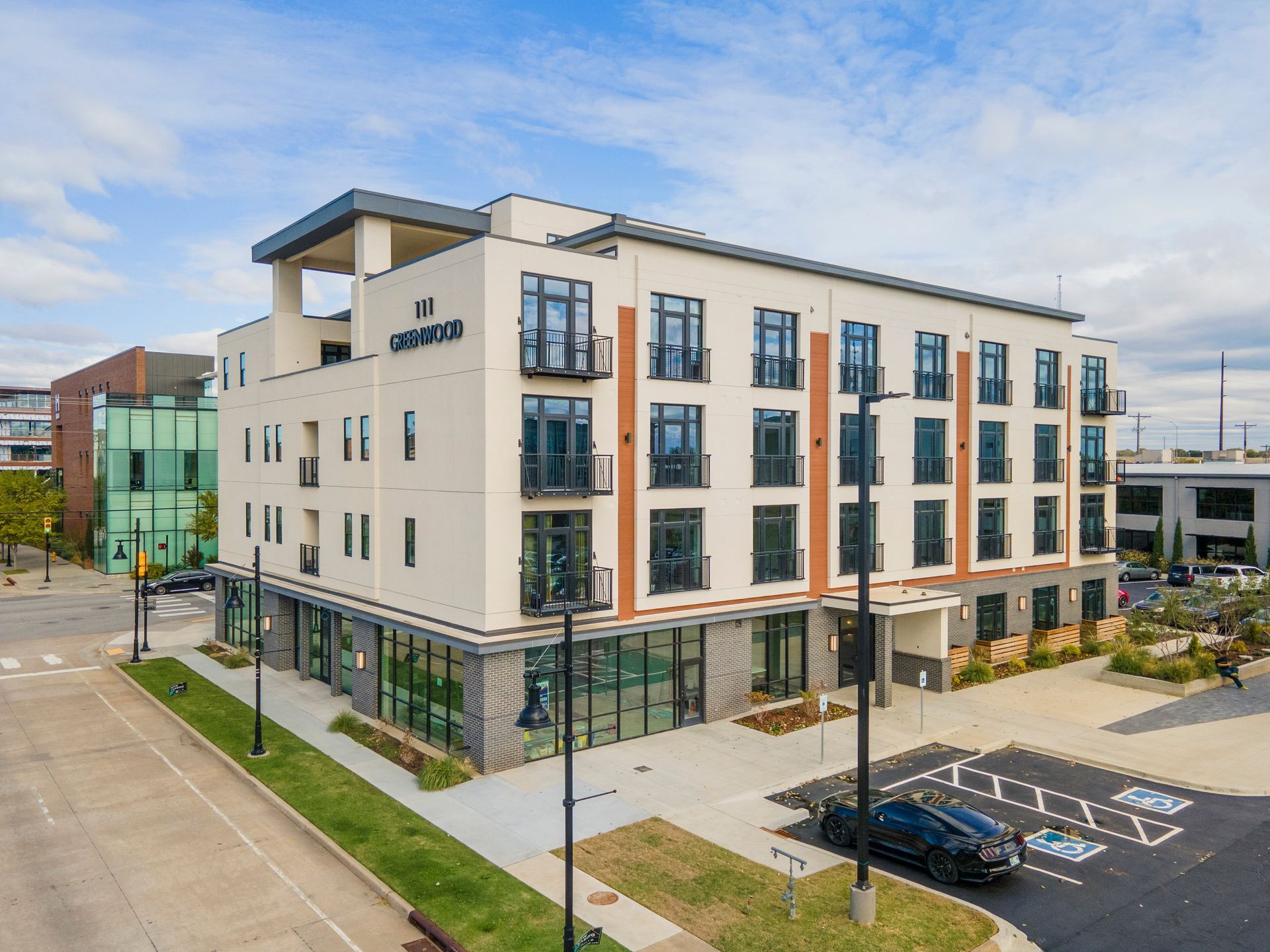 Modern multi-story building with glass windows, street view. 