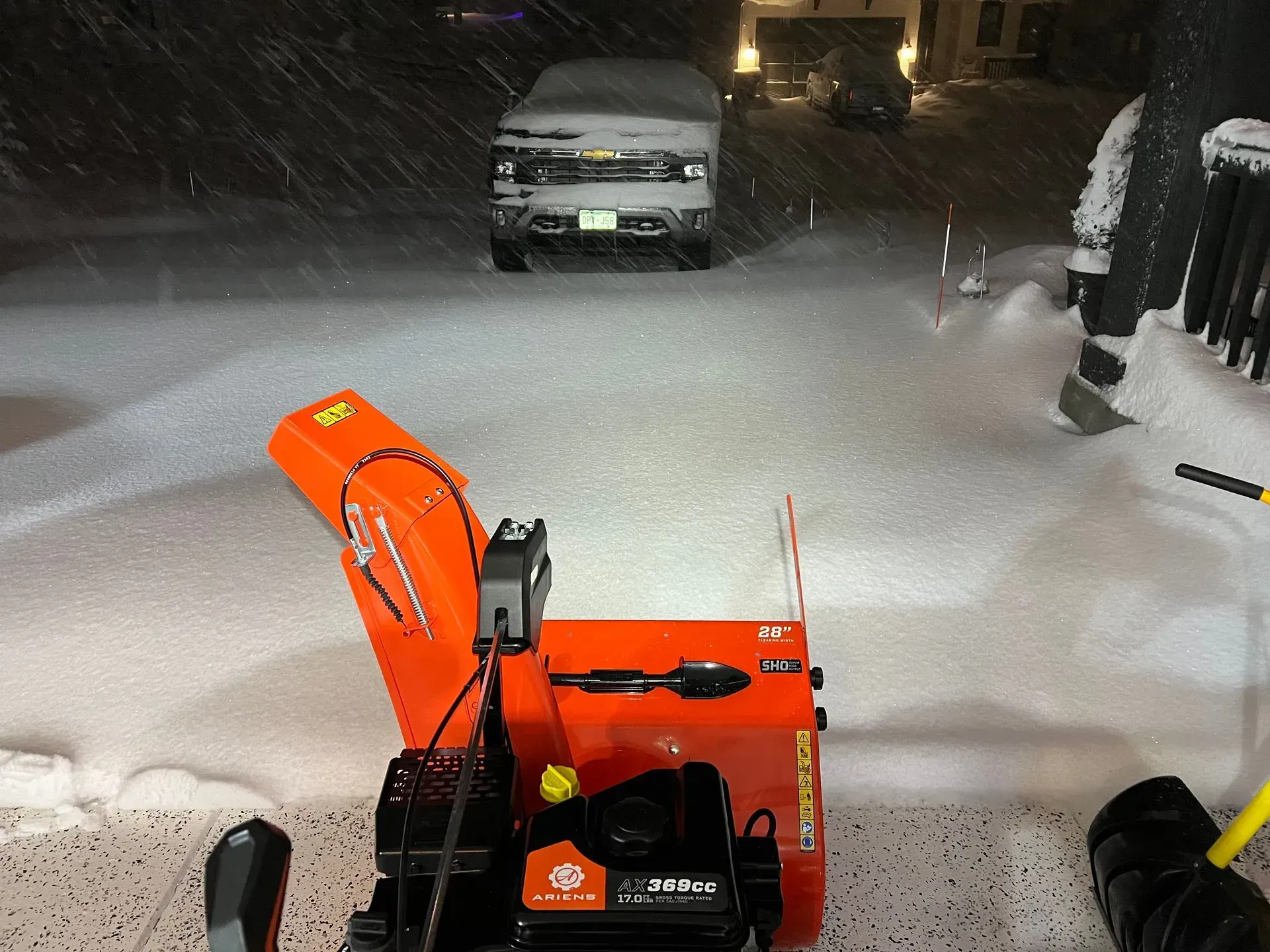 A skid steer snowplow clearing a snow-covered road.