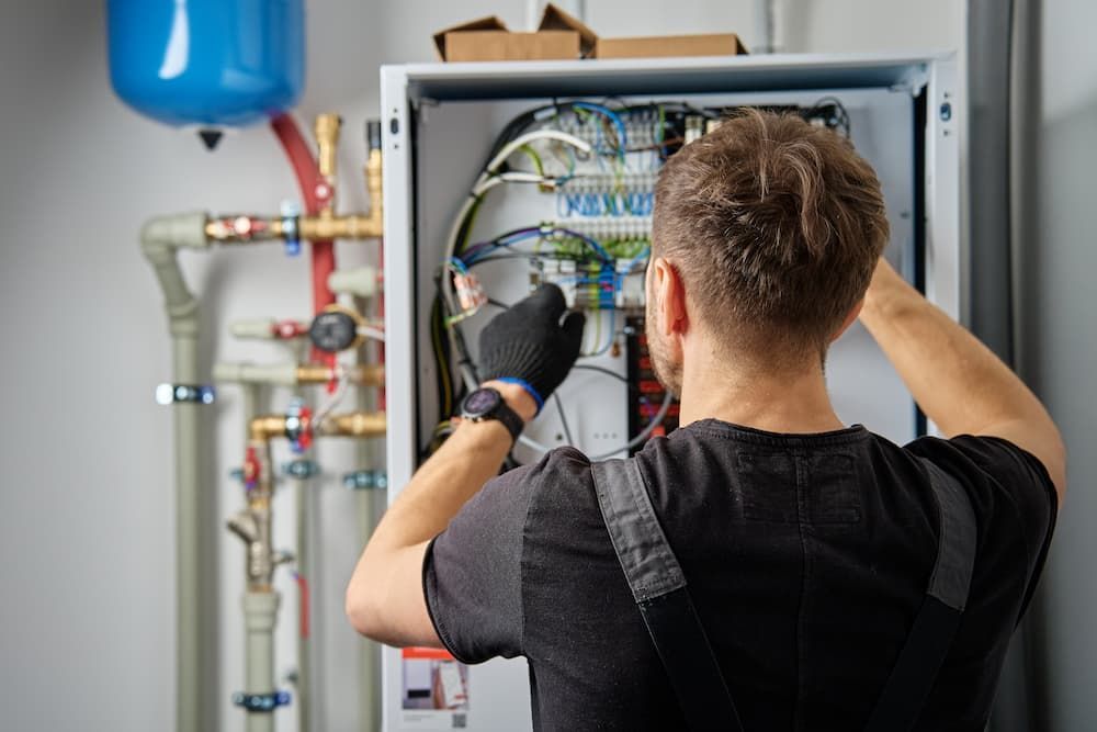 Technician checking wiring for a boiler, used for an electrical inspection checklist and safety comp