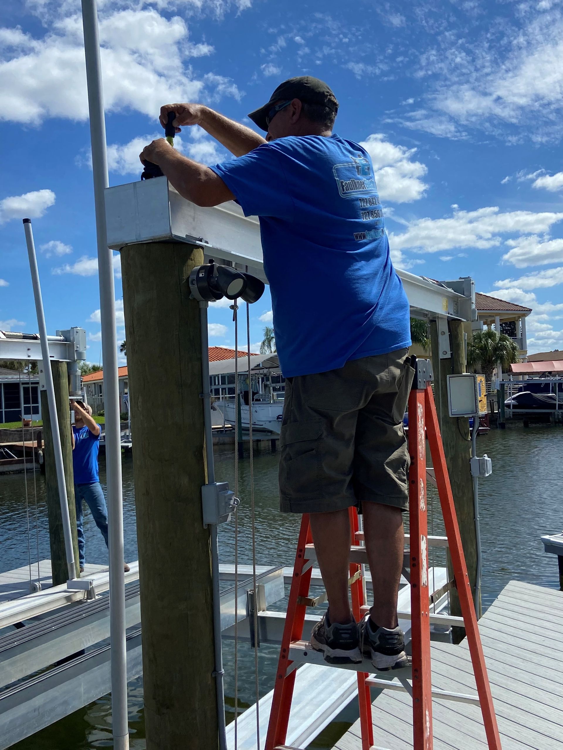 A man in a blue shirt is working on a dock