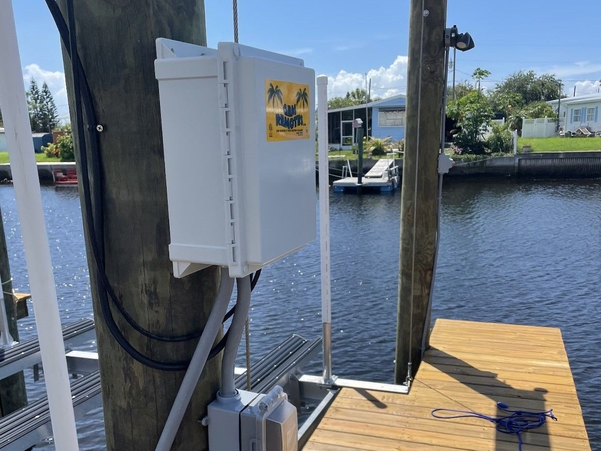 A white box is sitting on a wooden dock next to a body of water.