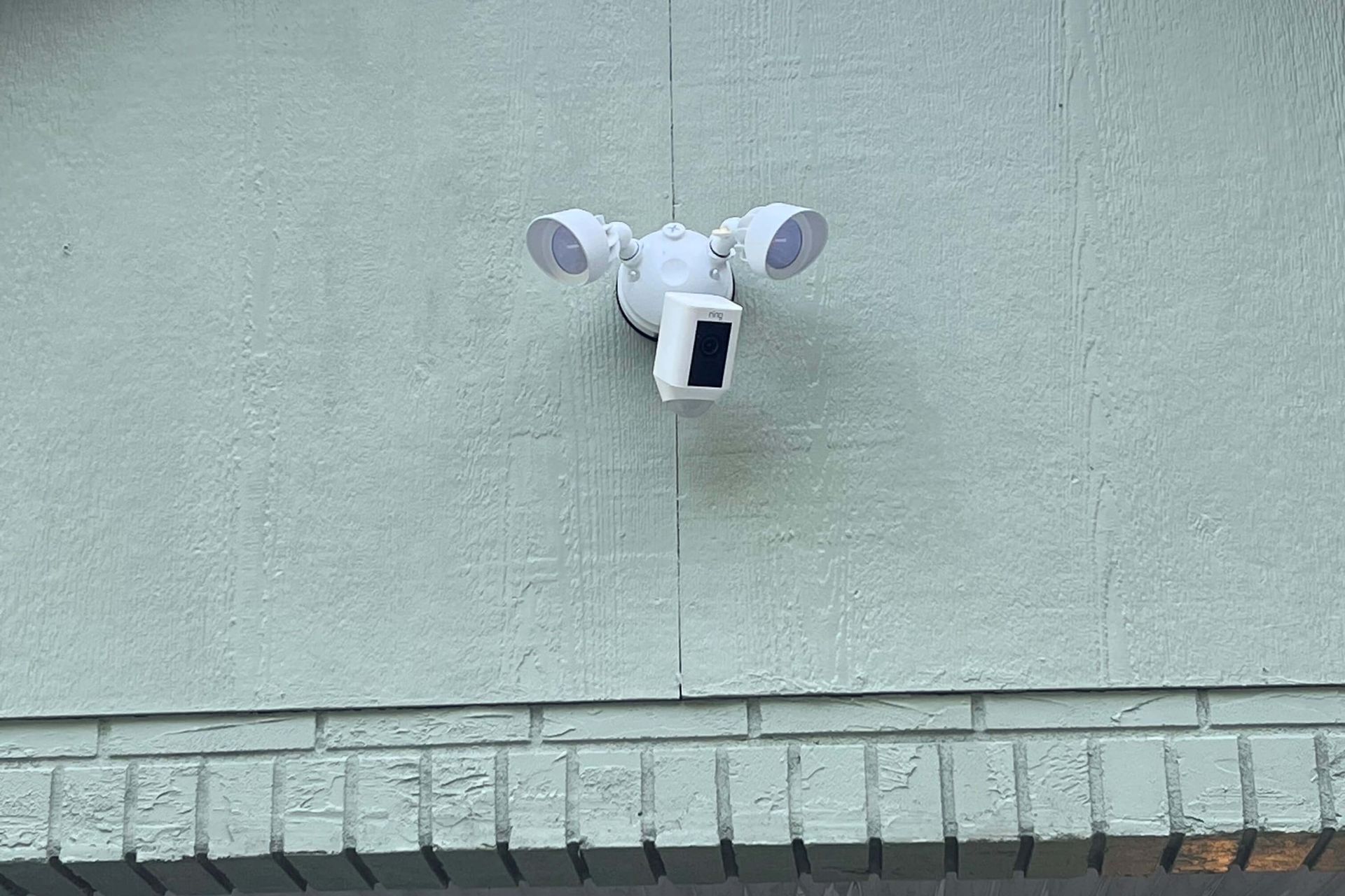 A security camera is mounted on the side of a building.