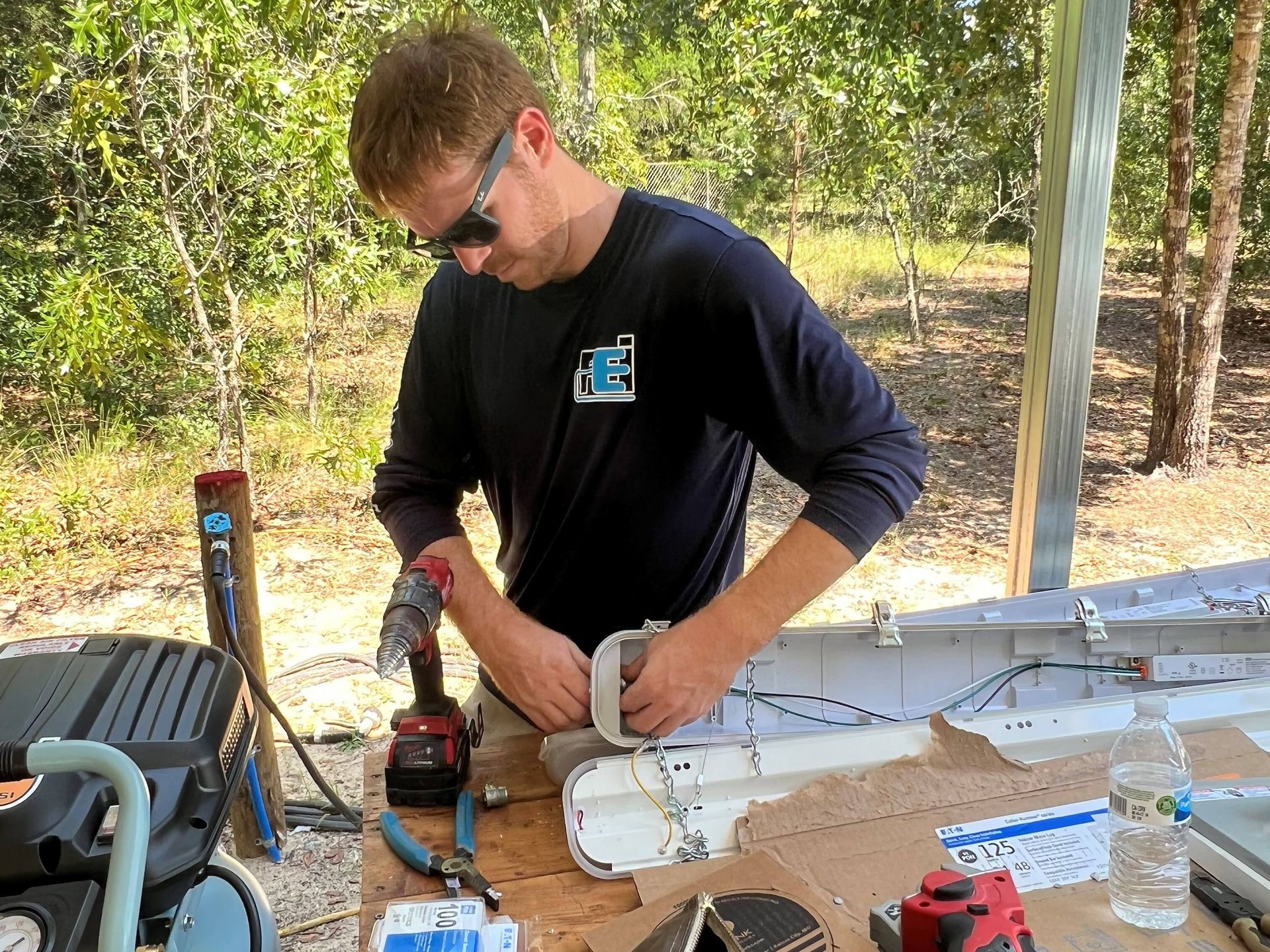 A man is sitting at a table working on a piece of equipment.