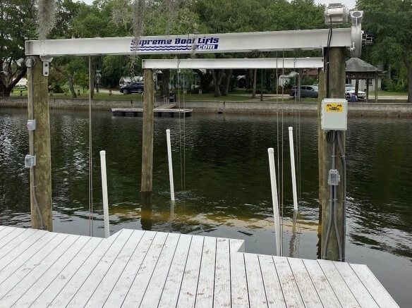 A dock with a supreme boat lift attached to it