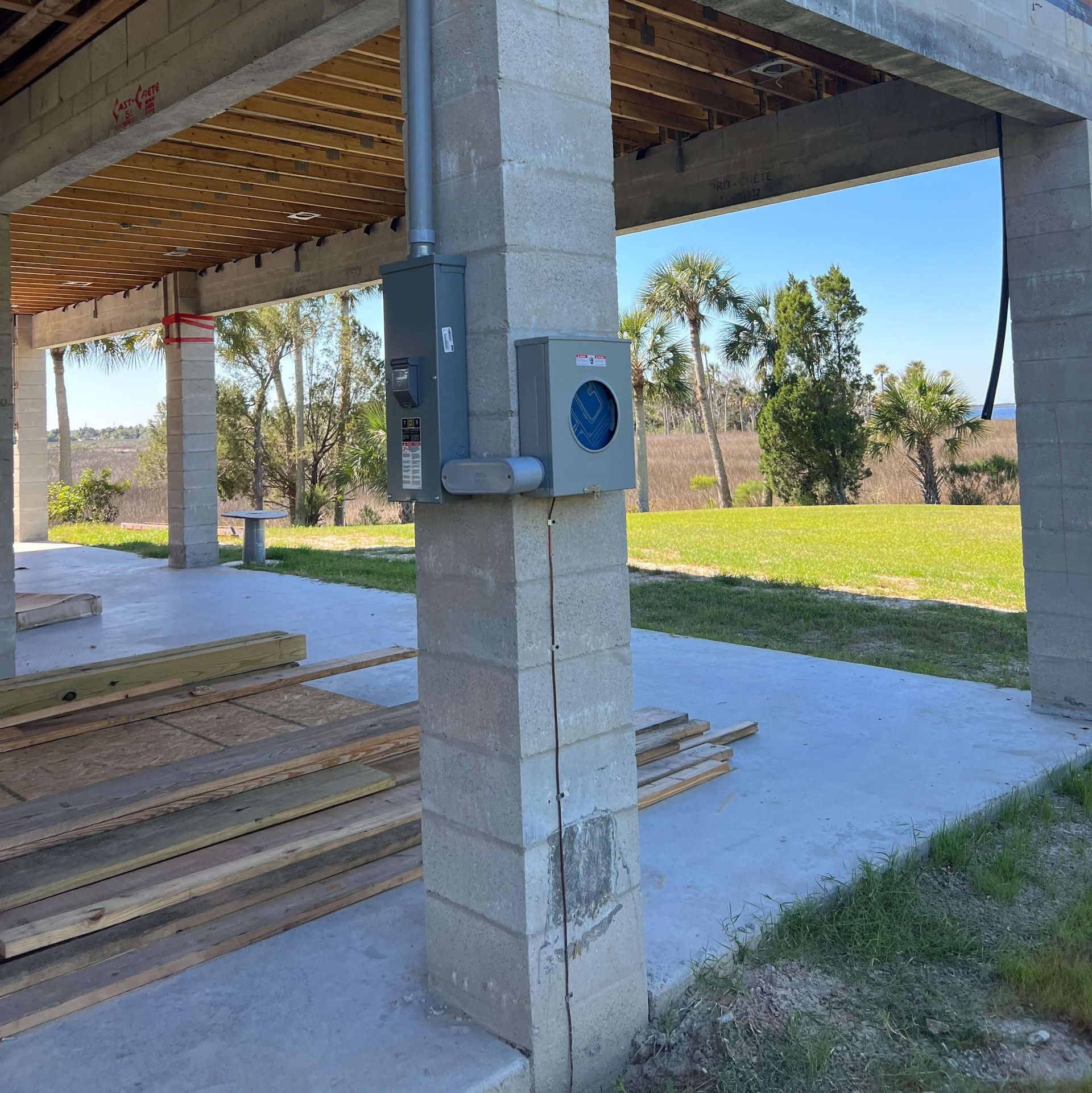 A box with a blue light on it is attached to a concrete pillar