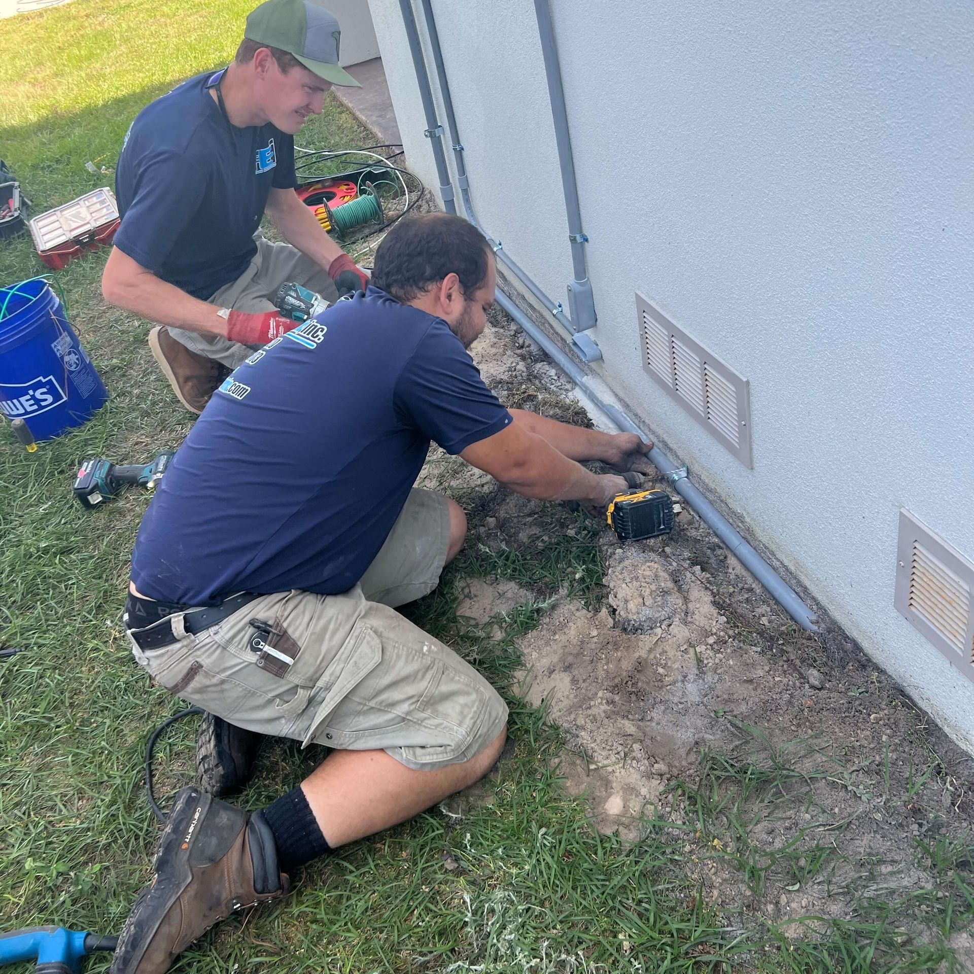 Two men are working on the side of a building