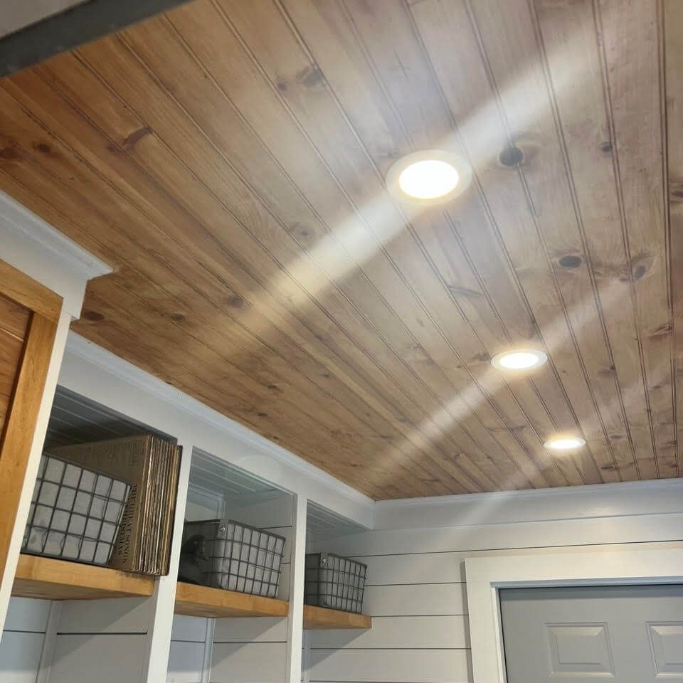 A room with a wooden ceiling and a gray door