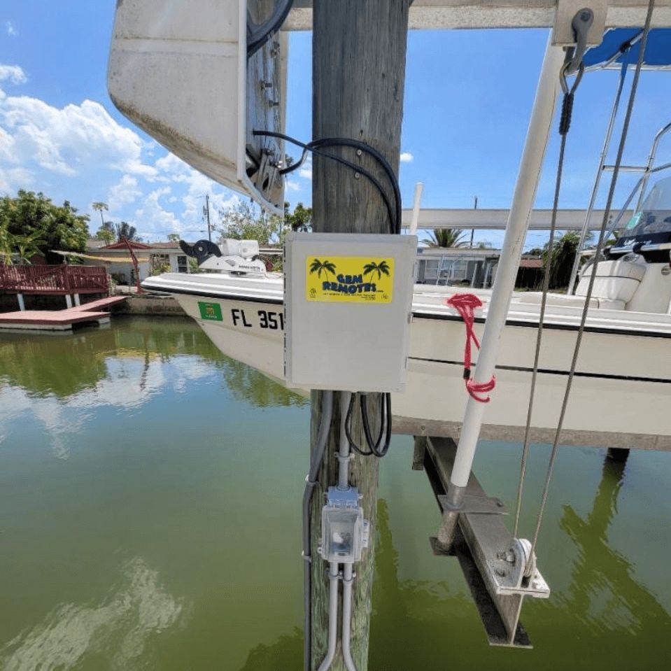 A boat is docked at a dock with a box attached to it.