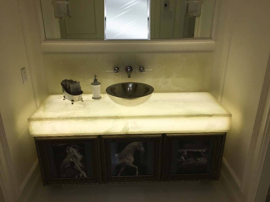 Un lavabo de salle de bain avec un comptoir éclairé et un miroir.