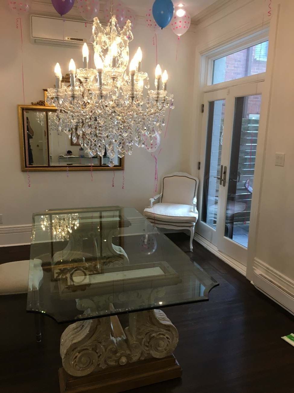 Une salle à manger avec un lustre et des ballons suspendus au plafond.