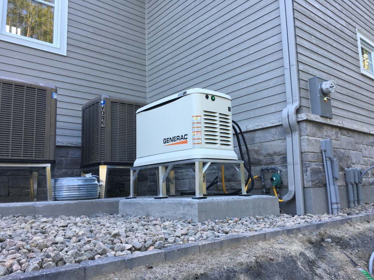 Un générateur est posé sur le côté d'une maison.