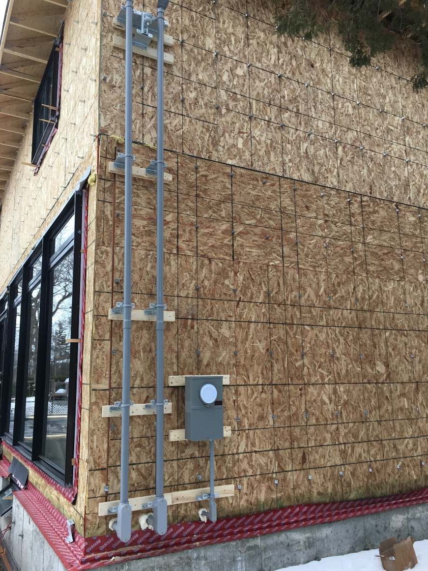 Une maison est en construction et il y a une boîte sur le côté de la maison.