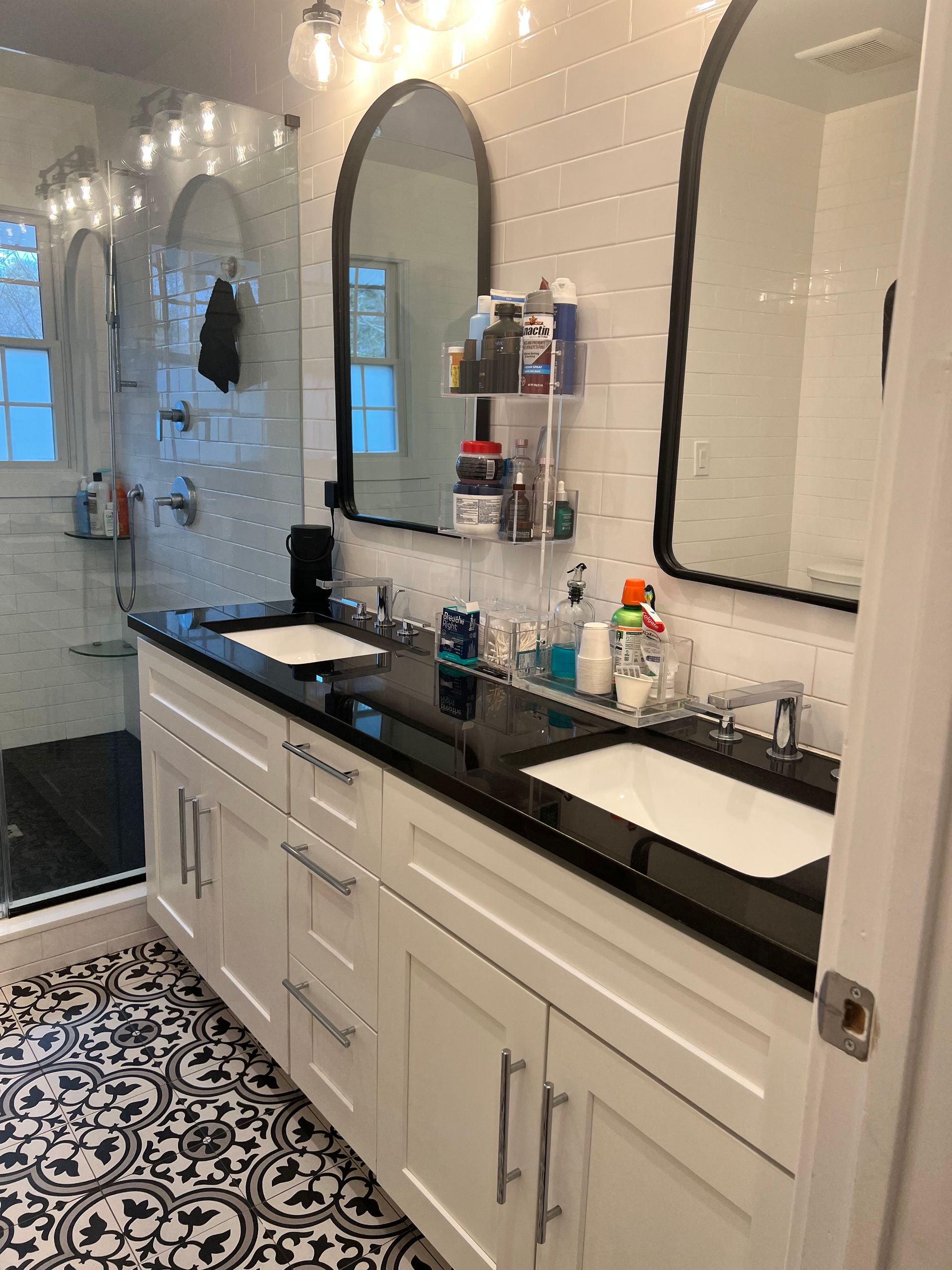 Amaya's Cleaning Service - A bathroom with two sinks , two mirrors and a walk in shower.