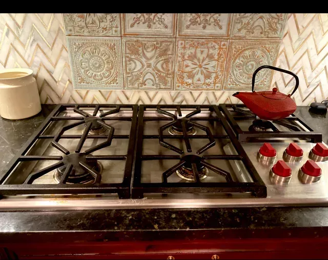 Amaya's Cleaning Service - A stove top oven with a teapot on top of it in a kitchen.