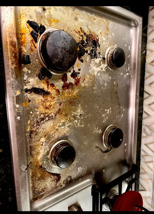 Amaya's Cleaning Service - A very dirty stove top with a lot of stains on it.