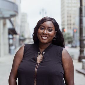 A woman in a black shirt is smiling for the camera