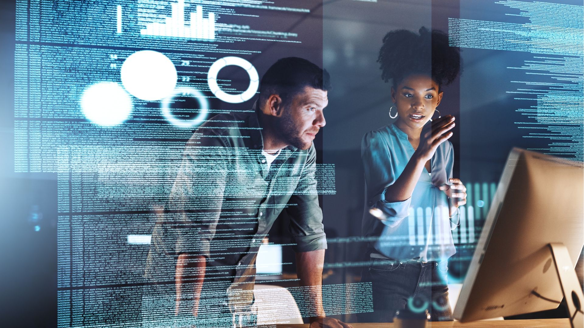 a man and a woman are looking at a computer screen