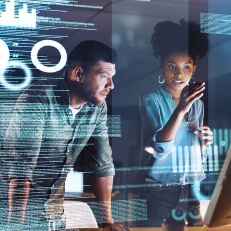 A man and a woman are looking at a computer screen.