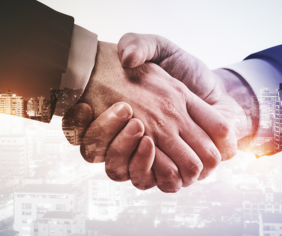Two people shaking hands, overlaid with a city skyline; a symbol of agreement or a deal.