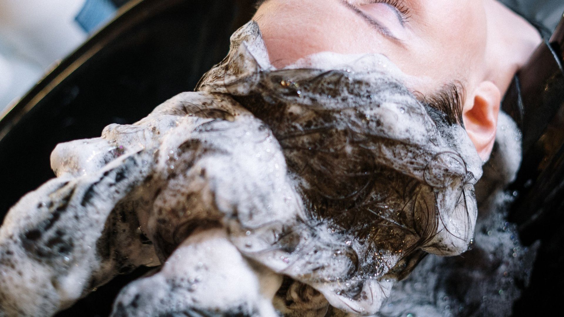 a woman is having her hair washed at a local salon in Keego Harbor, MI