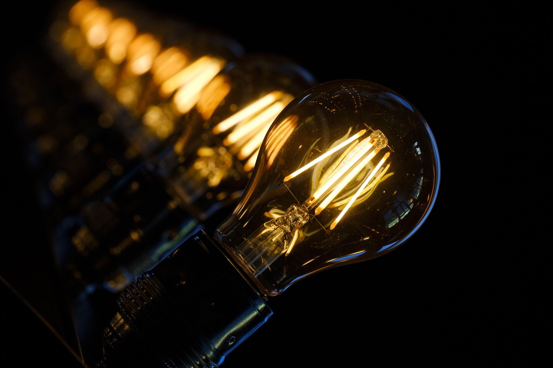Glowing vintage light bulb in close-up against a dark background