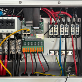 Electrical control panel with relays, terminal blocks, and red, yellow, and black wiring.