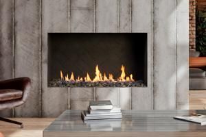Modern living room fireplace with flames, concrete surround, and glass coffee table