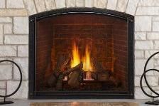 Lit fireplace with orange flames inside a brick surround, framed by black metal and stone walls
