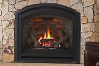 Stone fireplace with a burning fire behind a black arched insert