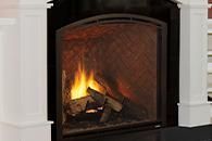 Lit fireplace with a black iron screen and white mantel surround