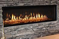 Modern stone fireplace with a long rectangular gas flame burning inside.