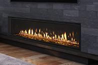 Modern black stone fireplace with a long row of flames above a wood floor