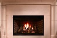 A lit fireplace with flames burning behind a black glass screen in a beige mantel surround
