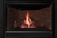 Lit fire in a black fireplace with glowing logs and visible flames.