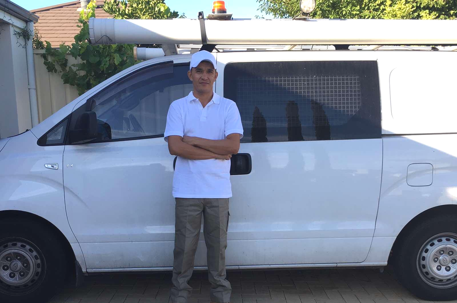 Jay from Blue Sky Painting (WA) logo standing front of his white van