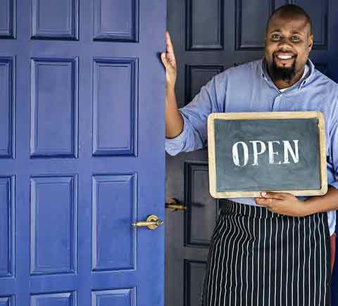 Business Insurance — Business Owner With Open Sign in Manchester, NH