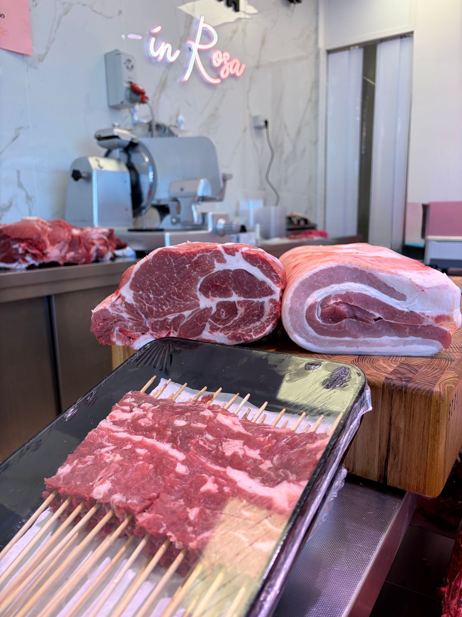 Fette di salumi marmorizzati esposte sul bancone di una macelleria.