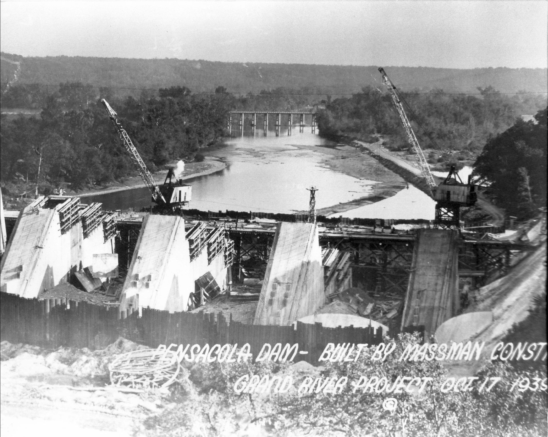 A black and white photo of a dam under construction