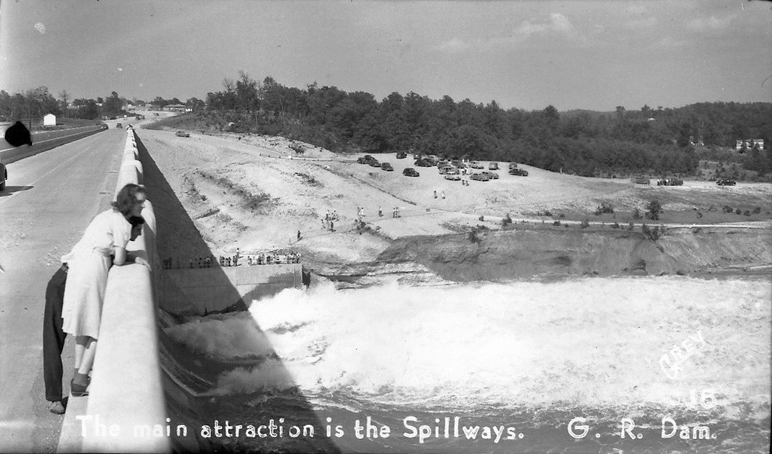 A black and white photo of a dam with the caption 