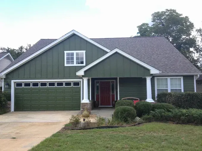 Green house with red door and white trim.
