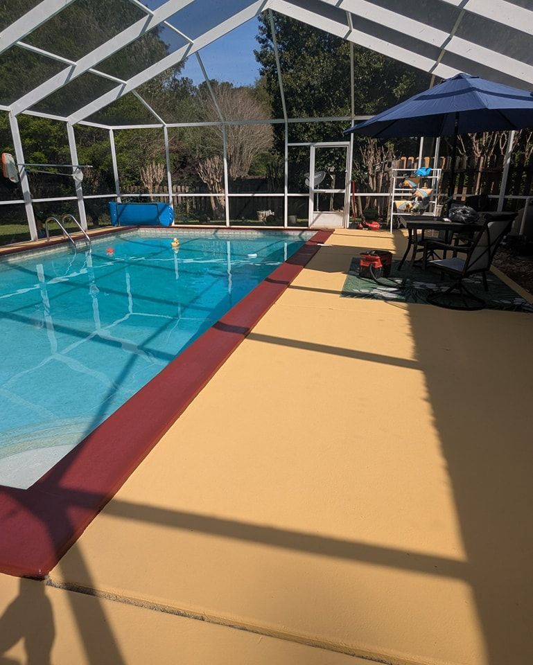 Pool area with screened enclosure; yellow deck, blue pool, red trim, umbrella, and table.