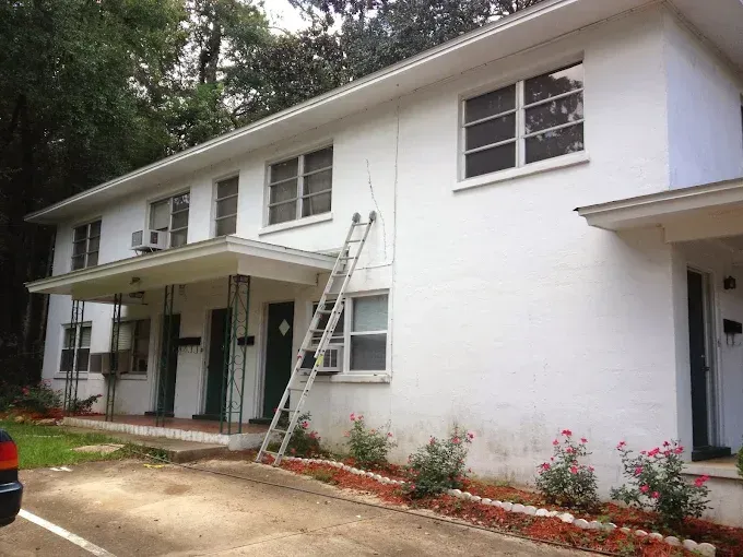 White apartment building with a ladder.