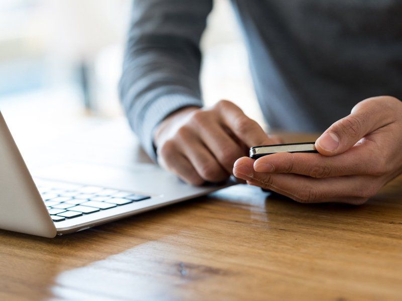 Man Holding Cellphone at Working Place — Omaha, NE — Arbor Heights Family Medicine