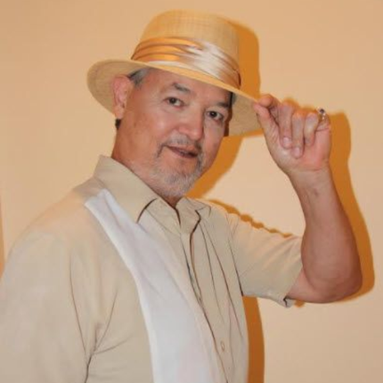Man in tan shirt and straw hat tipping his hat.