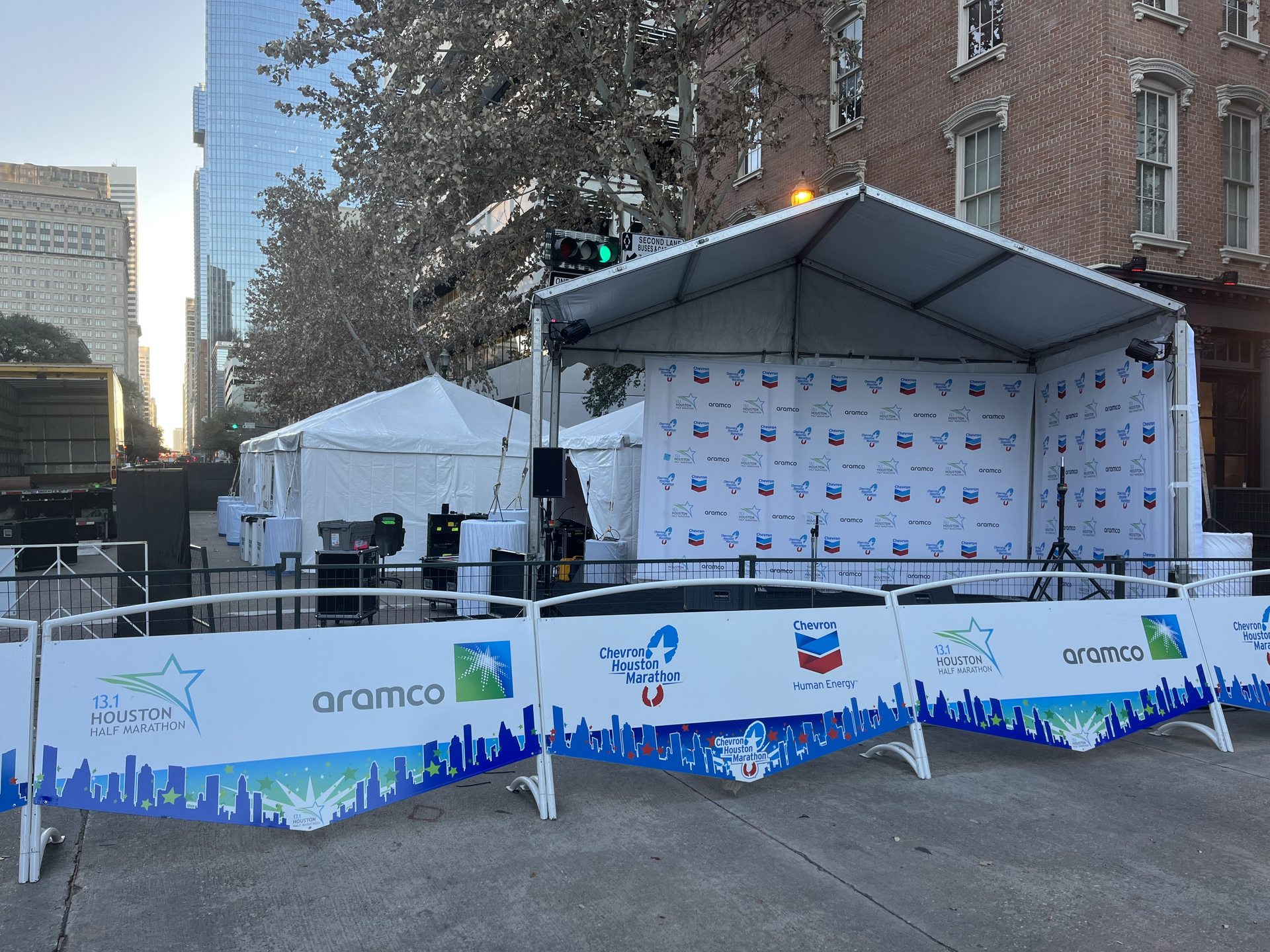 Stage with sponsor banners set up outdoors on a city street.