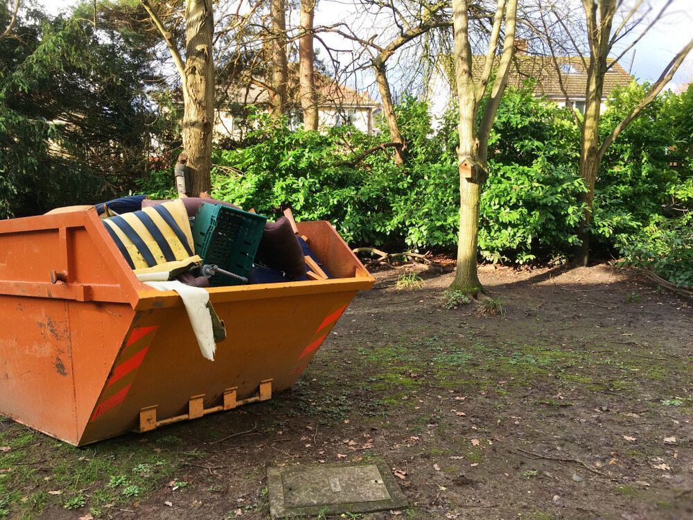 A large orange dumpster is sitting in the middle of a grassy field — Eco Skips In Midge Point, QLD
