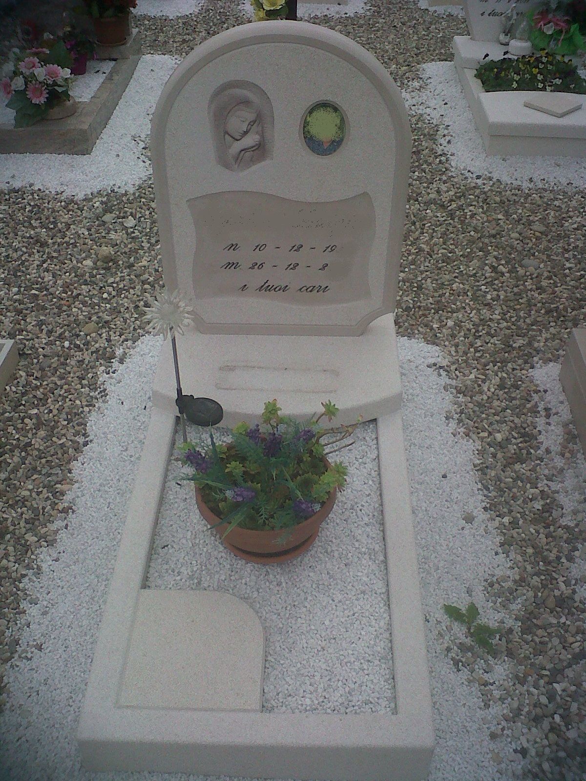 Una tomba in un cimitero con fiori in un vaso