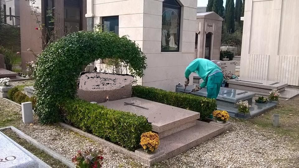 Un uomo sta lavorando su una tomba in un cimitero.
